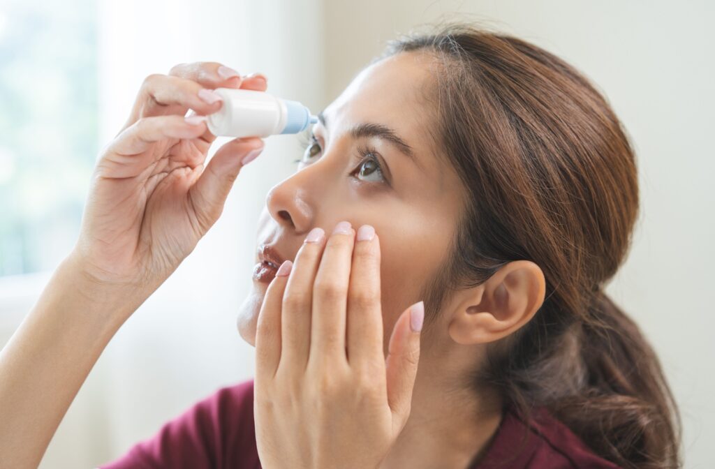 A person uses eye drops to soothe their dry eye symptoms.